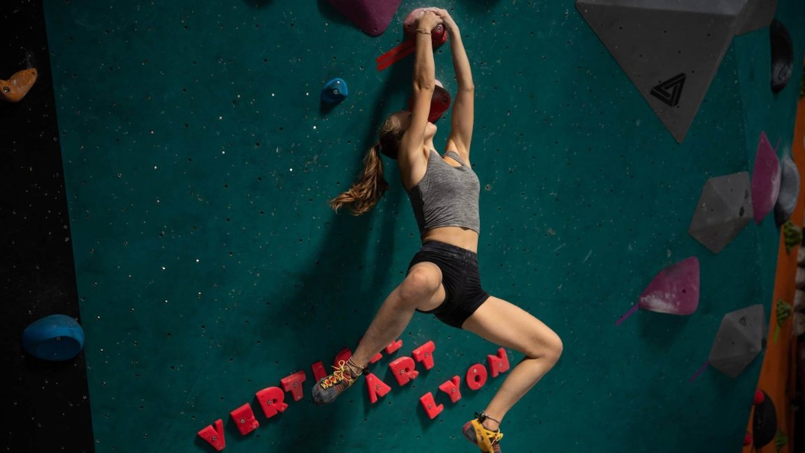 femme en pleine escalade acrobatique a la salle vertical art a lyon