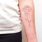 tatouage fleur minimaliste au bras realise au salon maison le loup a lyon