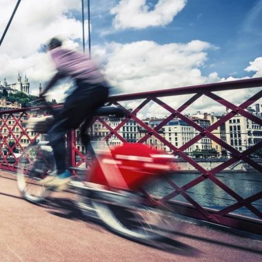 un velo en libre service traverse la passerelle saint georges a lyon