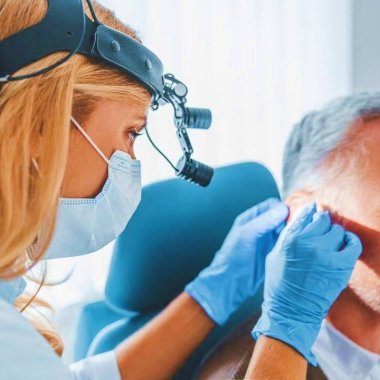une audioprothesistes lyonnaise pose une prothese auditive sur un patient
