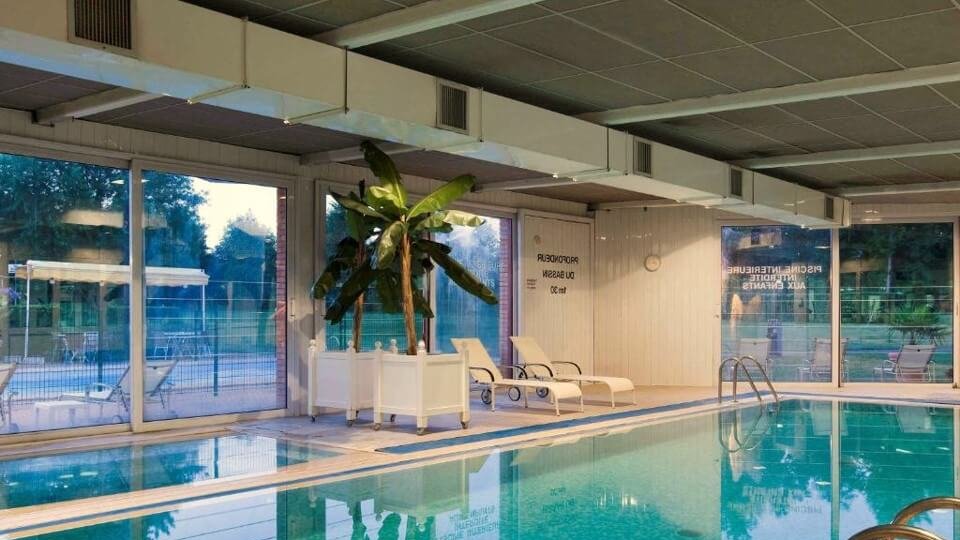 piscine interieure chauffee avec plage et transats dans l hotel mercure l lisle d abeau
