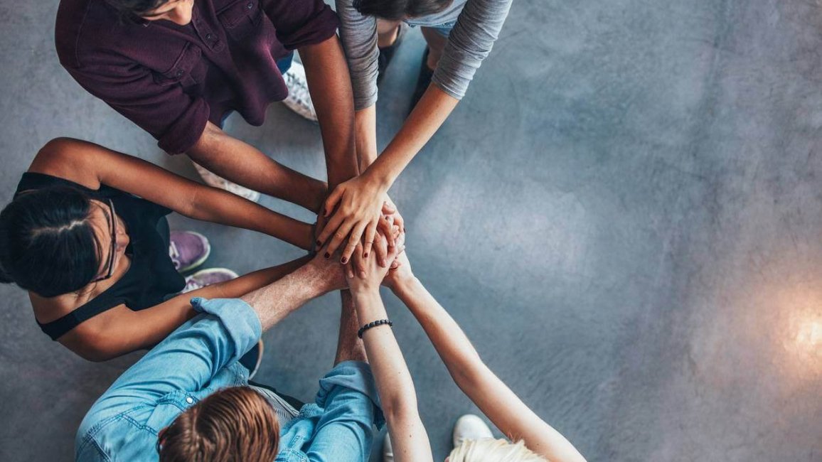 etudiants en groupe qui se joignent les mains