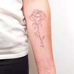 tatouage fleur minimaliste au bras realise au salon maison le loup a lyon