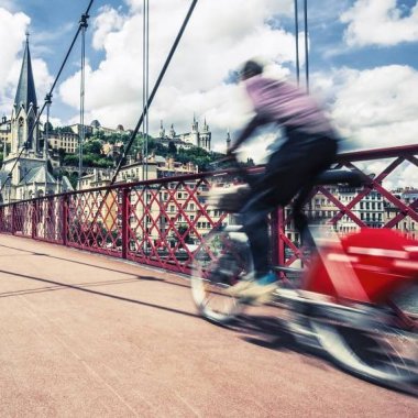 un velo en libre service traverse la passerelle saint georges a lyon